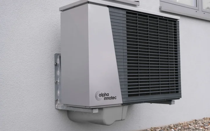 Modern residential air-source heat pump mounted on an exterior wall