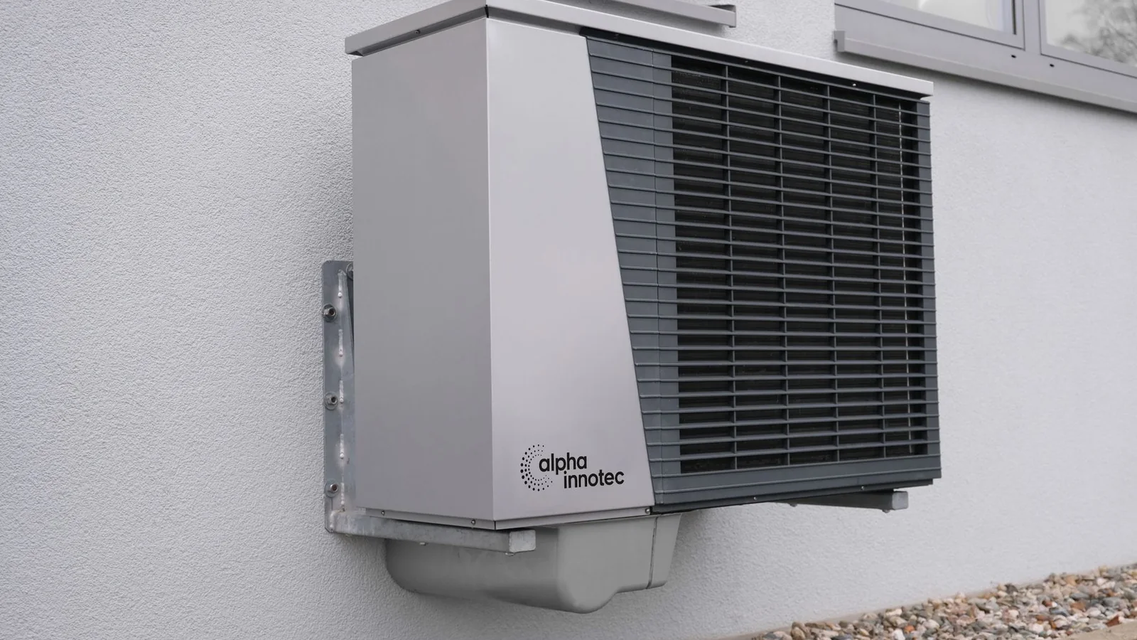 Modern residential air-source heat pump mounted on an exterior wall